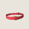 A hot pink dog collar made of smooth leather features a simple, minimalist design with a gold metal buckle. The collar is unembellished, highlighting its vibrant color and quality craftsmanship.