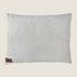 A soft, textured dog bed pillow in a neutral bouclé fabric featuring a light sage color. The bed has a small leather tag with the brand name Indie Boho stitched on one corner, adding a touch of elegance to the design.