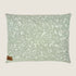 A rectangular dog bed featuring a soft sage green fabric adorned with a white floral and leaf pattern. The bed has a small tag in the lower corner that reads Indie Boho, emphasizing its stylish and cozy design.