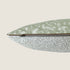 Close-up view of a dog bed featuring a textured bouclé fabric in neutral tones, with a sage green top displaying abstract brushstroke patterns. The design includes a zipper along one side for easy removal and cleaning of the cover.