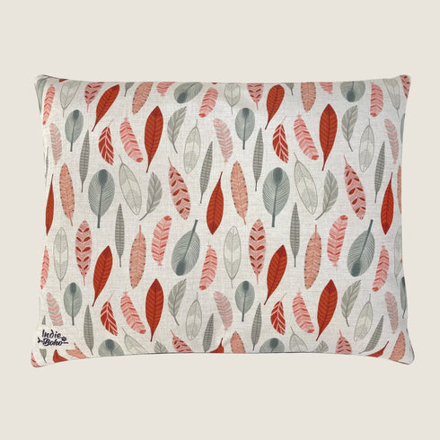 A rectangular dog bed featuring a linen-blend fabric adorned with a colorful pattern of leaves in shades of red, gray, and muted tones. The design showcases an artistic.
