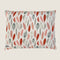 A rectangular dog bed featuring a linen-blend fabric adorned with a colorful pattern of leaves in shades of red, gray, and muted tones. The design showcases an artistic.