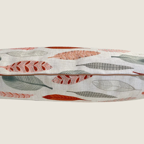 A close-up view of a dog bed featuring a linen-blend fabric adorned with colorful leaf patterns in shades of green, orange, and red.