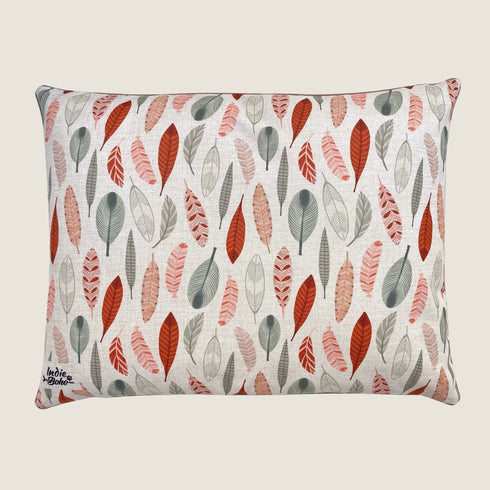 A decorative dog bed featuring a linen-blend cover adorned with a vibrant pattern of various leaves in shades of red, gray, and peach on a light background.