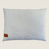A plush, rectangular pillow featuring a soft, textured bouclé fabric in a light cream color. The pillow includes a small brown label with the brand name Indie Boho stitched on one side.