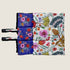 A colorful dog travel mat features vibrant illustrations of Australian wildflowers and plants, including pink, red, and green designs on a pale yellow background.