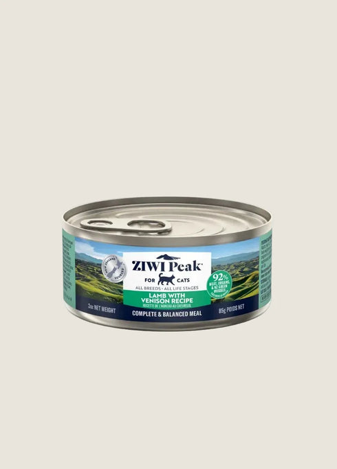 A can of ZIWI Peak Cat Food is displayed against a neutral background. The label features images of lush green landscapes and highlights the ingredients, including lamb and venison, along with the products nutritional benefits.