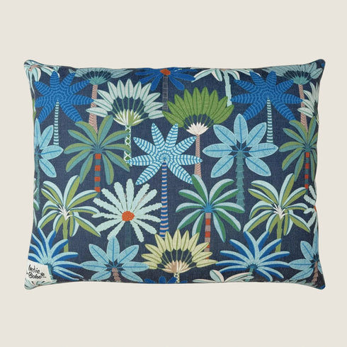 Decorative pillow with tropical palm tree and flower pattern on a blue background