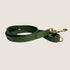 A classic green leather dog lead is displayed, featuring a smooth finish and sturdy construction. It has an antique brass clip for secure attachment, emphasizing both elegance and durability for active pets.