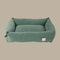 A plush, myrtle green corduroy pet bed with a rectangular shape and soft, padded sides. The bed features a simple, elegant design that blends seamlessly with home decor, offering comfort for pets.