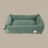 A plush, myrtle green corduroy pet bed with a rectangular shape and soft, padded sides. The bed features a simple, elegant design that blends seamlessly with home decor, offering comfort for pets.