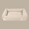 A plush, beige corduroy pet bed with a rectangular shape and softly padded sides, designed for comfort and style. The bed features a smooth interior and a subtle logo tag on one side.